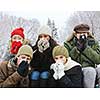 Group of diverse young friends blowing noses outdoors in winter