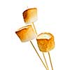 Three golden toasted marshmallows on wooden skewers
