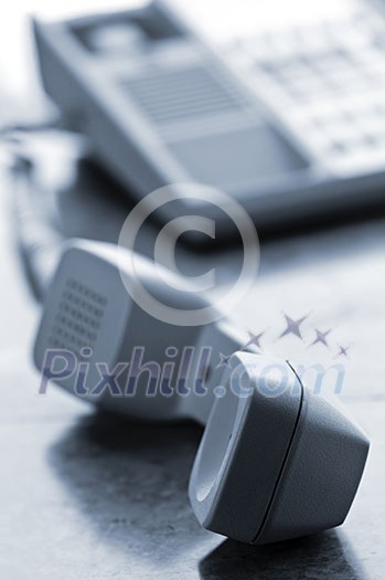 Telephone handset off the hook on desk