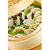 Closeup of bamboo steamer with cooked dumplings