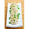 Plate of cooked chinese dumplings in a row