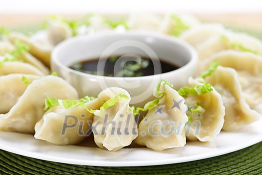 Closeup on plate of steamed dumplings with soy sauce Closeup on plate of steamed dumplings with soy sauce