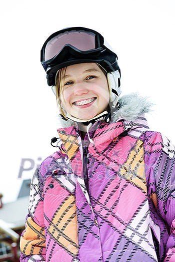 Portrait of happy teenage girl in ski helmet and goggles at winter resort Portrait of happy teenage girl in ski helmet and goggles at winter resort