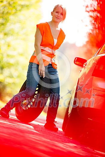 Young female driver wearing a high visibility vest, calling the roadside service/assistance after her car has broken down Young female driver wearing a high visibility vest, calling the roadside service/assistance after her car has broken down