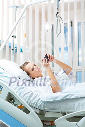 Pretty, young, female patient in a modern hospital room. Getting better fast after a surgery - pensive yet positive, thinking ahead, making plans (shallow DOF; color toned image) Pretty, young, female patient in a modern hospital room. Getting better fast after a surgery - pensive yet positive, thinking ahead, making plans (shallow DOF; color toned image)