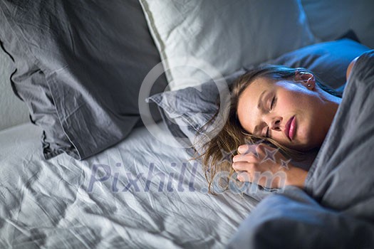 Beautiful young woman sleeping in bed (colour toned image; shallow DOF)