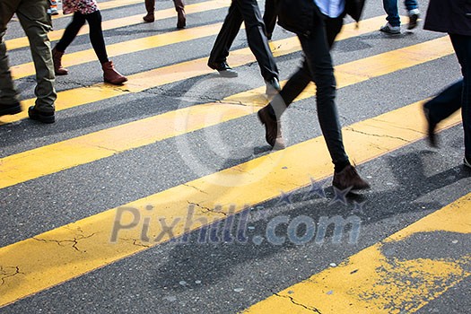 urban traffic concept - city street with a motion blurred crowd crossing a road