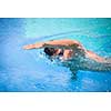 Young man swimming the front crawl/freestyle in a pool