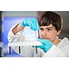 Young male researcher carrying out scientific research in a lab (shallow DOF; color toned image)