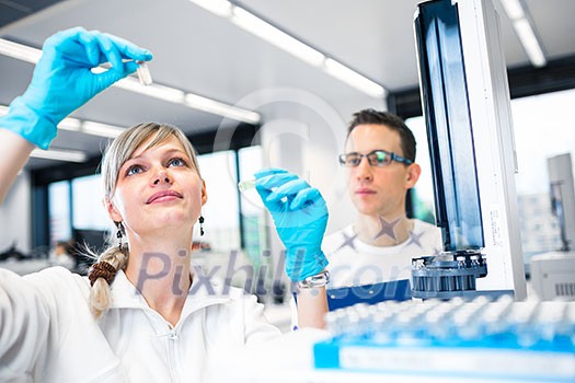 Two young researchers carrying out experiments in a lab (shallow DOF; color toned image)