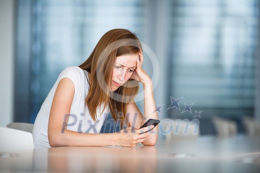 Depressed/anxious/unhappy young woman using her smart phone