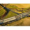 Aerial view of a highway amid fields with cars on it