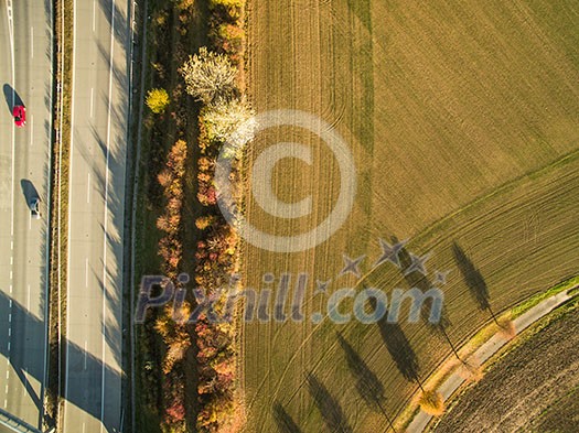 Aerial view of a highway amid fields with cars on it