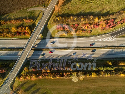 Aerial view of a highway amid fields with cars on it