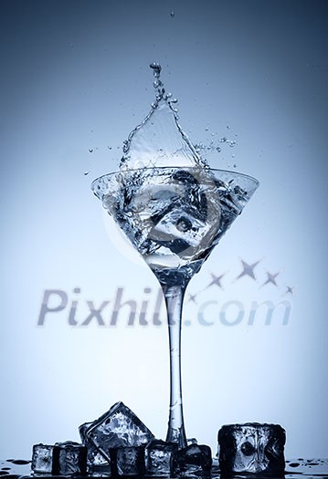 Water splash in glass with ice cubes. Water splash in glass with ice cubes.