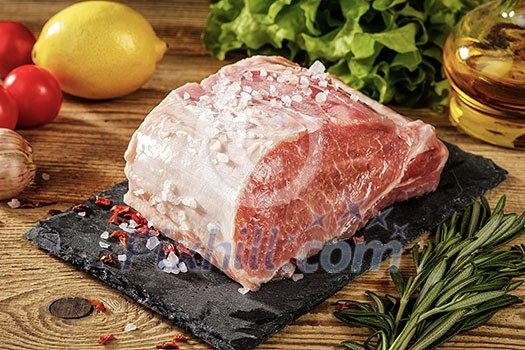 Top view on raw pork loin with salt and herbs