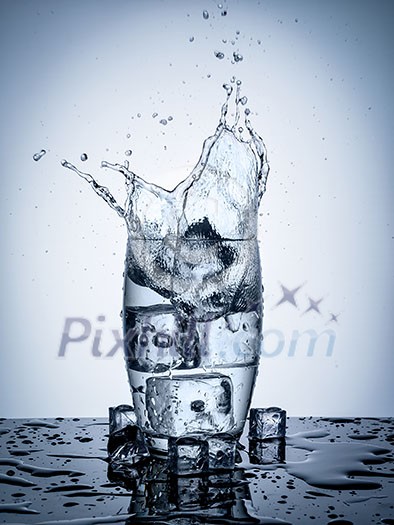 Water splash in glass with ice cubes. Water splash in glass with ice cubes.