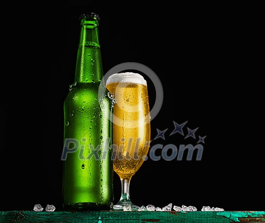 Bottle and glass of beer on the wooden table over black background Bottle and glass of beer on the wooden table over black background