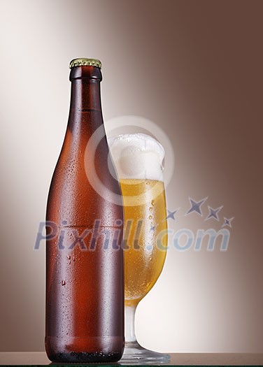 Cold Bottle and glass of beer on the table over beige background Cold Bottle and glass of beer on the table over beige background