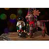 Toy figure wooden nutcracker statue and santas deer Roudolph standing in front of decorated Christmas lights, vintage style