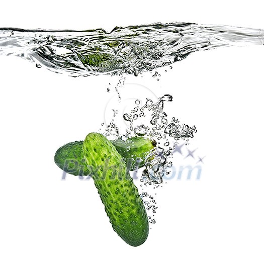 green cucumbers dropped into water isolated on white