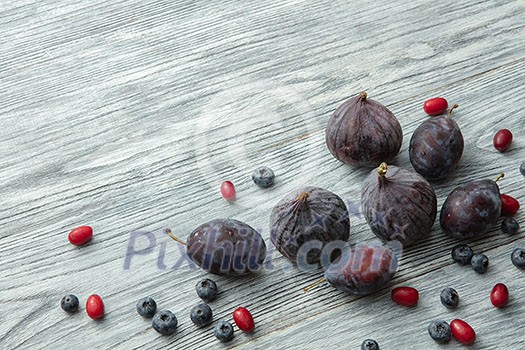 Fresh figs and blueberries on a gray wooden background