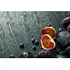sliced figs and ripe berries on a dark wooden background