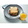 plate with grilled sandwich and orange juice on white table