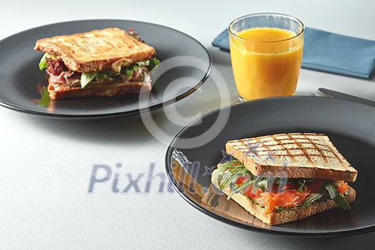 Breakfast Club Sandwich with orange juice on a table Breakfast Club Sandwich with orange juice on a table