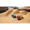 multicolored game dice for gambling, isolated on a brown background