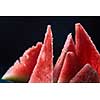 Triangle shaped watermelon slices on dark grungy background . Top view.