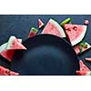 slices of watermelon placed near the plate black isolated on black