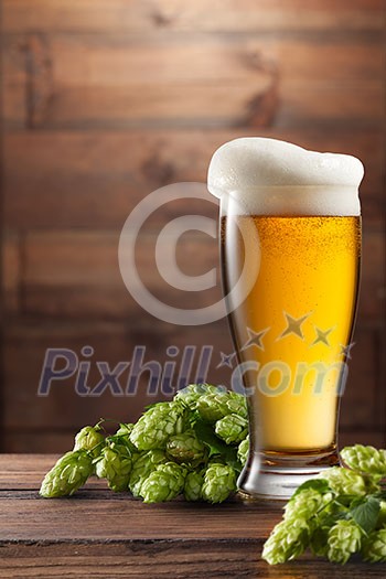 keg of beer and hops on a brown wooden background keg of beer and hops on a brown wooden background