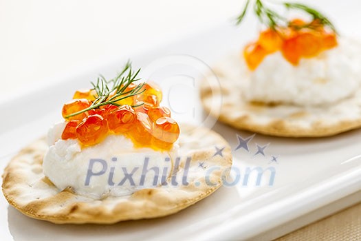 Closeup of caviar and cream cheese appetizer on crackers