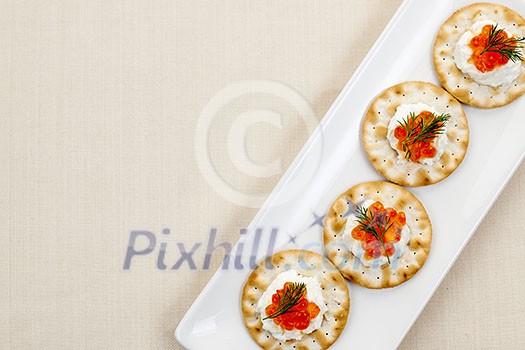 Caviar and goat cheese appetizer on white plate from above with copy space