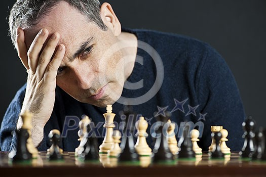 Chessboard with man thinking about chess strategy Chessboard with man thinking about chess strategy