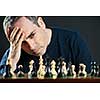 Chessboard with man thinking about chess strategy