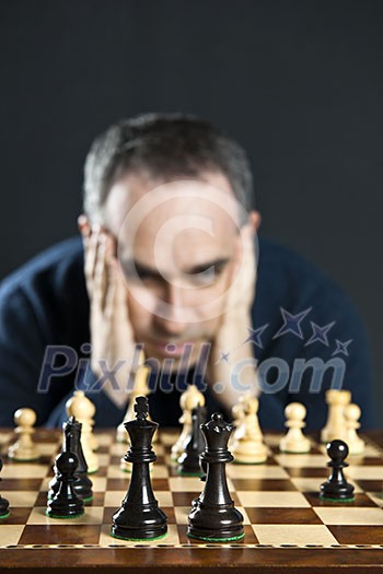 Chessboard with man thinking about chess strategy Chessboard with man thinking about chess strategy