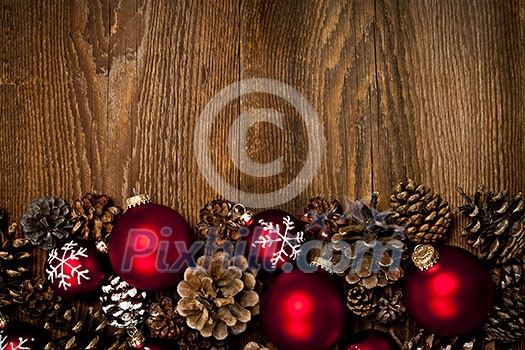 Rustic wood background with Christmas ornaments and pine cones Rustic wood background with Christmas ornaments and pine cones