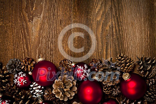 Rustic wood background with Christmas ornaments and pine cones