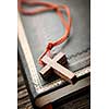 Closeup of simple wooden Christian cross necklace on holy Bible