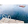 Dock and ladder on calm summer lake with diving platform in Ontario Canada