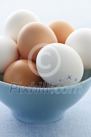 Closeup of white and brown eggs in bowl