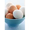 Closeup of white and brown eggs in bowl