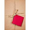 Gift package and red card in brown paper wrapper tied with string close up