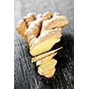 Close up of sliced fresh ginger root spice on wooden table