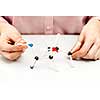 Hand of female student assembling amino acid molecule models for science project