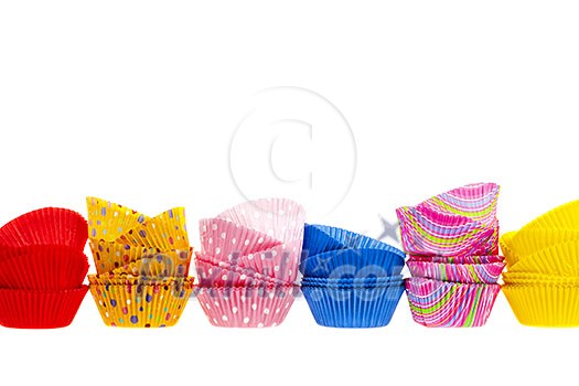Several stacks of colorful muffin or cupcake cups isolated on white background as border Several stacks of colorful muffin or cupcake cups isolated on white background as border