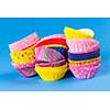Several stacks of colorful muffin or cupcake cups on blue background