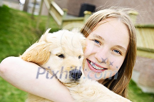 Portrait of smiling teenage girl holding golden retriever puppy Portrait of smiling teenage girl holding golden retriever puppy